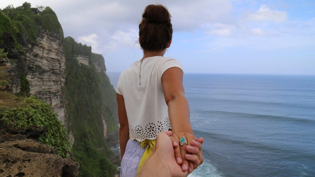 cliff, beach, holding hands